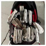 TaylorMade, Z|I Theta, and Mizuno clubs, in a red and yellow Titleist golf bag [bag appearing in ove