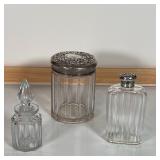 (3pc) SILVER & GLASS JARS | Including two jars with sterling silver lids decorated en repousse (lids