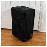 TUMI CARRY-ON | Black Tumi carry on suitcase, rolling; h. 23 x 14 x 9-1/2 in.