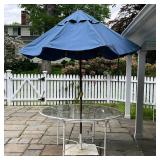 PATIO DINING TABLE | Round white framed glass top outdoor dining table with a Basta Sole umbrella on