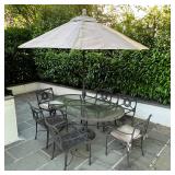 oval shaped glass top dining table with 8 arm chairs and an umbrella with stand; table h. 30 x 74 x 