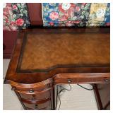 inset leather top and two banks of three drawers, center drawer front folds down for use as a keyboa