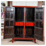Red lacquered cabinet, with double doors opening to reveal two drawers between open shelves, with br