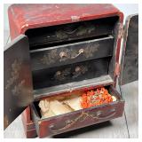 with patinated pressed brass hardware, having two doors revealing three black lacquered interior dra