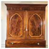 mahogany and walnut, having double cabinet doors with veneer arched panels, opening to reveal one fu