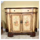 single drawer over two cabinet doors with a faux painted floral decoration, with shaped sides and fr