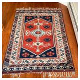 SMALL AREA RUG | With central medallion on a rust field within concentric borders with geometric dev