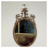 FRENCH STYLE MIRROR | Wall mirror with a fancy frame, crested by an urn with flowers and having scro