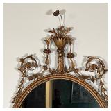 Wall mirror with a fancy frame, crested by an urn with flowers and having scrollwork on the sides - 