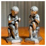 PAIR PEWTER BOOKENDS | The Jennings Bros Manufacturing Company, weighted, in the form of putti scrib