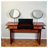 drawers with black triangular pulls centering a unique lift top compartment, having two round mirror