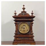ANSONIA SHELF CLOCK | Carved oak wood case with three finials and brass appliqué, the face with Arab