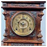 wood case with three finials and brass appliqué, the face with Arabic numerals, the movement marked 
