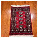 BOKHARA MAT | With five central medallions within a flower border, on a red ground - 3 ft. 2 in. x 2