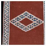 FLAT WOVEN MAT | With a central diamond, and overall diamond and triangle pattern on a brown field -