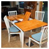 dining table with self-contained table leaf, the table with a wood board top and white legs, with fo