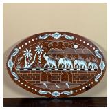 INLAID BONE ELEPHANT PLAQUE | Oval wood plaque with inlaid engraved bone depicting elephants crossin