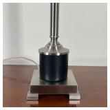 lamp with a brushed chrome column on a square base, with black leather wrapping at the bottom - over