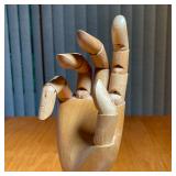 Having five articulating fingers and a movable wrist on a weighted base with felt bottom - h. 11 in.