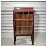 Of small size, with paneled glazed door and sides, interior with three shelves, including two remova