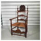 19th century, carved wood armchair crested by an intricately carved shield, with rush seat - h. 43-1