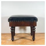 piano stool, having a padded black leather top with brass tacks on an adjustable wood base over flut