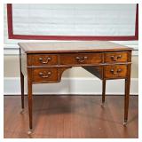 LEATHER TOP WRITING DESK  | Having an inset leather top tooled with gilding, having five drawers on 