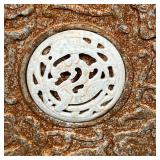 circular stone carved with animals and flowering branches surrounded by eight segments forming a lar