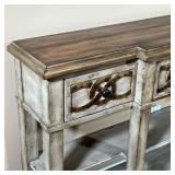 Metallic scrollwork design on a rustic distressed painted wood frame, three drawers over two open sh