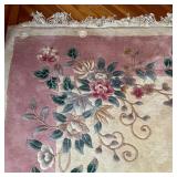 Nichols-style rug, having a beige ground with scrolling floral sprays and a light pink border - l. 1