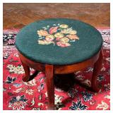 NEEDLEPOINT FOOTSTOOL  |  20th century, a cluster of flowers on a green ground, over cabriole legs -
