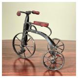 MINIATURE TRICYCLE  | Small articulating metal tricycle having red wooden handle bars and a red wood