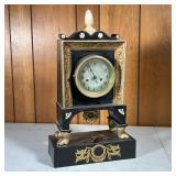 ORNATE SHELF CLOCK | Black and gilt shelf clock with an alabaster finial and applied accents; engine