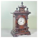 MUSICAL OAK SHELF CLOCK | Having a carved decorated oak case, steel and brass movement engraved