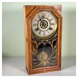 WATERBURY CLOCK CO. SHELF CLOCK | Brass surrounded clock face with Roman numeral markers behind