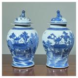 (2pc) PAIR BLUE & WHITE GINGER JARS | Chinese lidded jars crested by foo dog finials, each showing a