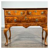 WALNUT VENEERED LOWBOY | Having two drawers over a full width drawer, sculpted apron, cabriole legs