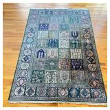 GEOMETRIC FLORAL RUG | Green rug with fringe, having a geometric outer border surrounding a field of