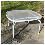 PATIO DINING TABLE | Outdoor dining table having a white tube frame with frosted glass top over four