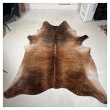 SADDLEMANS STEER HIDE RUG | Free-form cow hide rug, brown with stripes and marked with brand and oth