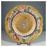 CAPODIMONTE PORCELAIN PLATE | Gilt plate with raised border depicting various nature scenes featurin