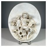 CERAMIC RELIEF PLAQUE | Showing a bard with lite holding a cupid before a rose bush, with blue crown