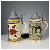 (2PC) GERMAN STEINS | Both stamped “Germany” on the bottom and with pewter hinged lids, including a 