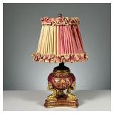 PAINTED FRENCH LAMP | French porcelain table lamp with gilt highlights and dolphin supports, with in