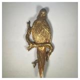 GILT CARVED PARROT | Gilt over red, with black painted eyes, perched on a sinuous branch.