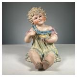 BISQUE PIANO BABY | Piano baby with a spoon and bowl in hand and dressed in a green nightgown Dimens