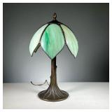 ART NOUVEAU SLAG GLASS LAMP | Table lamp with green petal-form slag glass shade on a tree trunk form