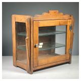 ART DECO TABLETOP DISPLAY CASE | Circa 1920s, wooden display case with glass front door and side pan