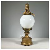 BRASS FIGURAL "LEAP FROG" LAMP | Electric brass/bronze base with a milk glass globe shade and a cast