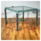 VERDIGRIS LOW TABLE | Green patina frame, having a beveled glass top and an X-form stretcher. - l. 3